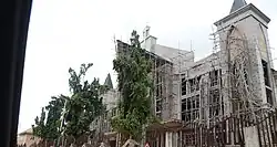 Eingerüstetes Kirchengebäude von vorn in Farbe.