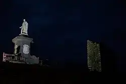 Bei Nacht aufgenommenes Foto einer angestrahlten weißen Statue.