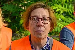 Stefanie Hoster trägt eine orangene Warnweste und schaut in die Kamera