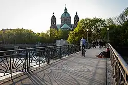 Fahr- bzw. Lauffläche mit Jugendstilgeländer. Die Kirche im Hintergrund ist St. Lukas