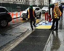 New York: Lüftungsgitter im Straßenraum werden vor einem Sturm gegen eindringendes Wasser geschützt