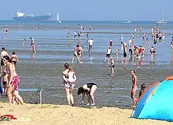 Niedrigwasser am Strand mit Watt, dahinter Jade-Fahrrinne nach Wilhelmshaven