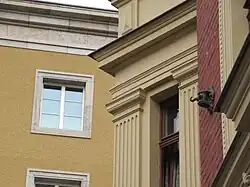 Oberleitungsrosette Brennerstraße 2, im Hintergrund das Gauforum in Weimar, dessen Bau die Ära der Straßenbahn in Weimar beendete