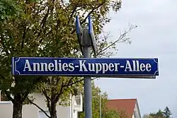 Blaues Straßenschild mit weißem Schriftzug Annelies-Kupper-Allee