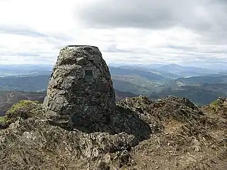 Aussichtstafel am Gipfel, Blick nach Südwest. Der kegelförmige hohe Berg im rechten Viertel ist der 25 km entfernte Schiehallion