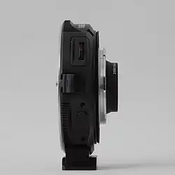 Seitenansicht mit Blendensteuerung (oben, Wipptaster) und USB-Anschluss (unten, hinter Gummikappe)