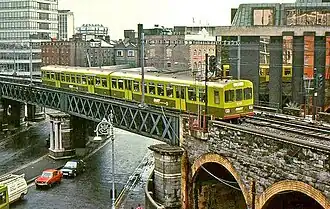 Elektrischer Zug der 8100 Class des DART in ursprünglicher Farbgebung auf der Loopline Bridge über die Lower Gardiner Street in Dublin (1986)