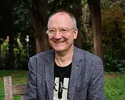 Porträt von Thomas Brussig, im Hintergrund Bäume in einem Park