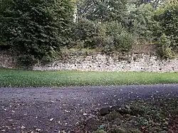 Trockenmauer Obstgarten von Belvedere mit einem Stück Rasen und angelegtem Wegstück