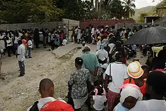 Einwohner von Côteaux vor einer Krankenstation der US Army (2010)