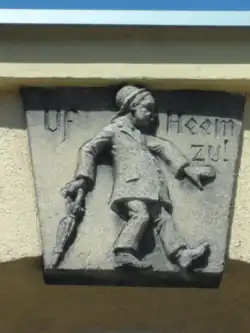 Reichenbach (Eulengeb.) - Zwei Reliefs: (l.) Uf Heem zu! (Auf dem Weg nach Hause)   (r.) Komm mer ock! (Komm mir nur! (Mit dem Finger drohend.))