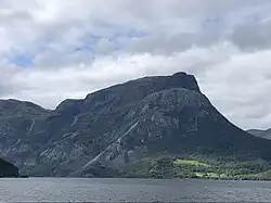 Foto eines Sees, auf dessen gegenüberliegender Uferseite ein Berg liegt