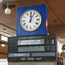 Historischer Anzeiger mit hinterleuchteten Einzelfeldern für Linie, Abfahrtsbahnsteig und nächsten abfahrenden Zug (Uxbridge, London)