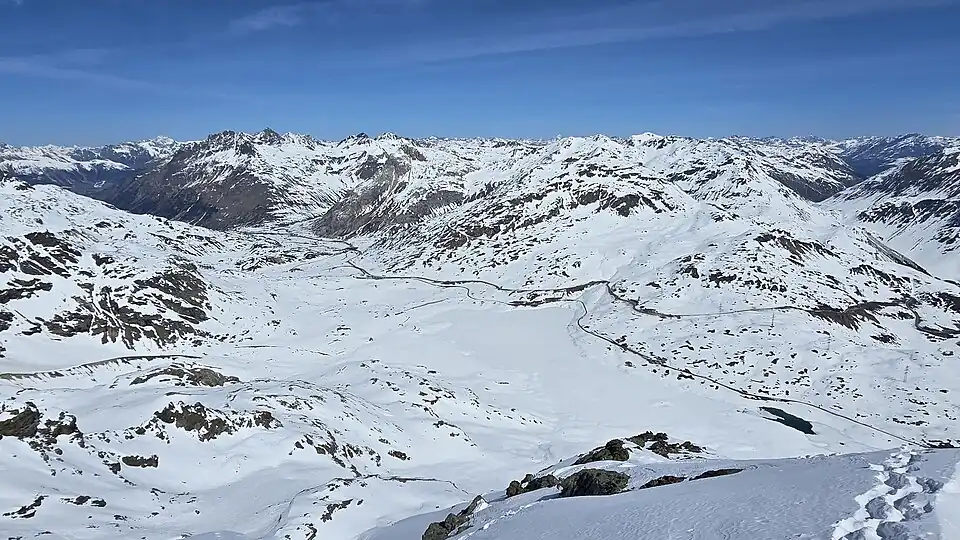 Blick nach Norden in die Val Bernina mit dem Berninapass (2235 m), den gefrorenen Seen Lago Bianco, Lej Nair und Lej Pitschen und der Berninabahn (für Annotationen aufs Bild klicken)