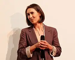 Valerie Eickhoff vor weißer Filmleinwand mit Mikro