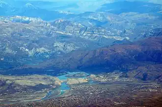 Luftaufnahme (2016) mit Mjeda in der Mitte unten und Laç rechts der Dämme, dahinter den See und die Albanischen Alpen