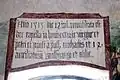 Die lateinische Inschrift über dem Fenster der rechten Apsiswand besagt, dass die Kapelle 1515 wiedergeweiht wurde zur Ehre der Jungfrau Maria, der Apostel Petrus und Paulus, der Heiligen Michael, Wolfgang und Ottilie und der 14 Nothelfer. Die Laibung des Fensters ist mit Ranken verziert.