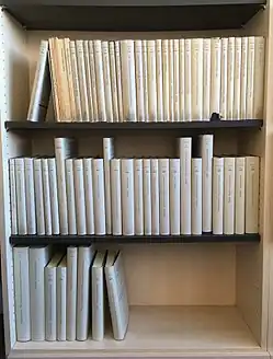 Ein Foto der etwa 70 erschienenen Vestigia-Bände, in einem Bücherregal, auf drei Regalbretter verteilt