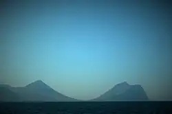 Der Norden der Insel Viðoy von Osten aus betrachtet. Die Umrisse von Malinsfjall sind links und die von Villingadalsfjall mit Enniberg rechts zu sehen. In der Mitte das Dorf Viðareiði.