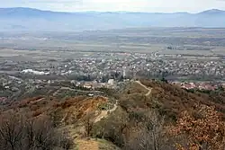 Ausblick von den Pyramiden von Stob auf den Ort Stob, im Vordergrund der Pfad entlang des Berggrates, hinter dem Zaun links befindet sich ein Teil der Sand(stein)Pyramiden
