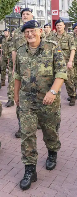 Foto zeigt den Oberst Torsten Grefe in seiner Bundeswehruniform seitlich von vorne. Er lächelt in die Kamera.