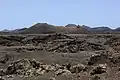 Vulkankegel Montaña de las Lapas auf Lanzarote, umflossen von erstarrter, aschebedeckter Lava