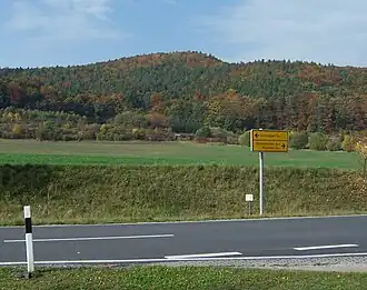 Blick von Neustädt nordwestwärts zum Kirchwaldskopf; im Vordergrund die L 1021 beim Abzweig der K 505