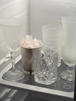 Cocktailgläser und ein Julep-Becher mit Crushed Ice im Tiefkühler