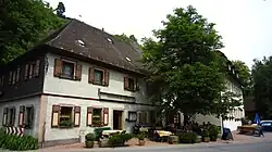 Der Landgasthof Zur Forelle. Vorne: Historisches Gastwirtschaftsgebäude, hinten: neuerer Hotelanbau