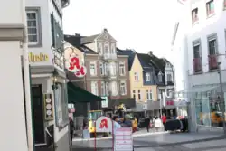 Blick auf die untere Wilhelmstraße. Links die Fassade der „Privilegierten Apotheke“, in der Mitte die Gebäude Wilhelmstraße 45, 47 (gelbe Fassade) und 49, rechts im Bild Wilhelmstraße 42