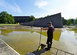 Arbeiter reinigen den sinkenden Mauerteich