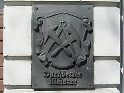 Zunftzeichen der Dachdecker: Dachdeckerbeil, Schieferhammer, Zirkel