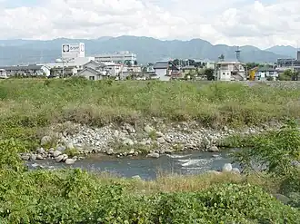 Stadtzentrum von Yamanashi vom Fluss Fuefuki aus gesehen