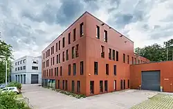 Dreistöckiges Gebäude mit gepflastertem Vorplatz