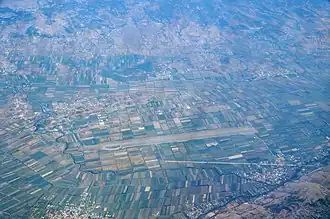 Zadrima mit dem Flugplatz und dem Dorf Gjadër unten rechts am Hügelrand (2017)